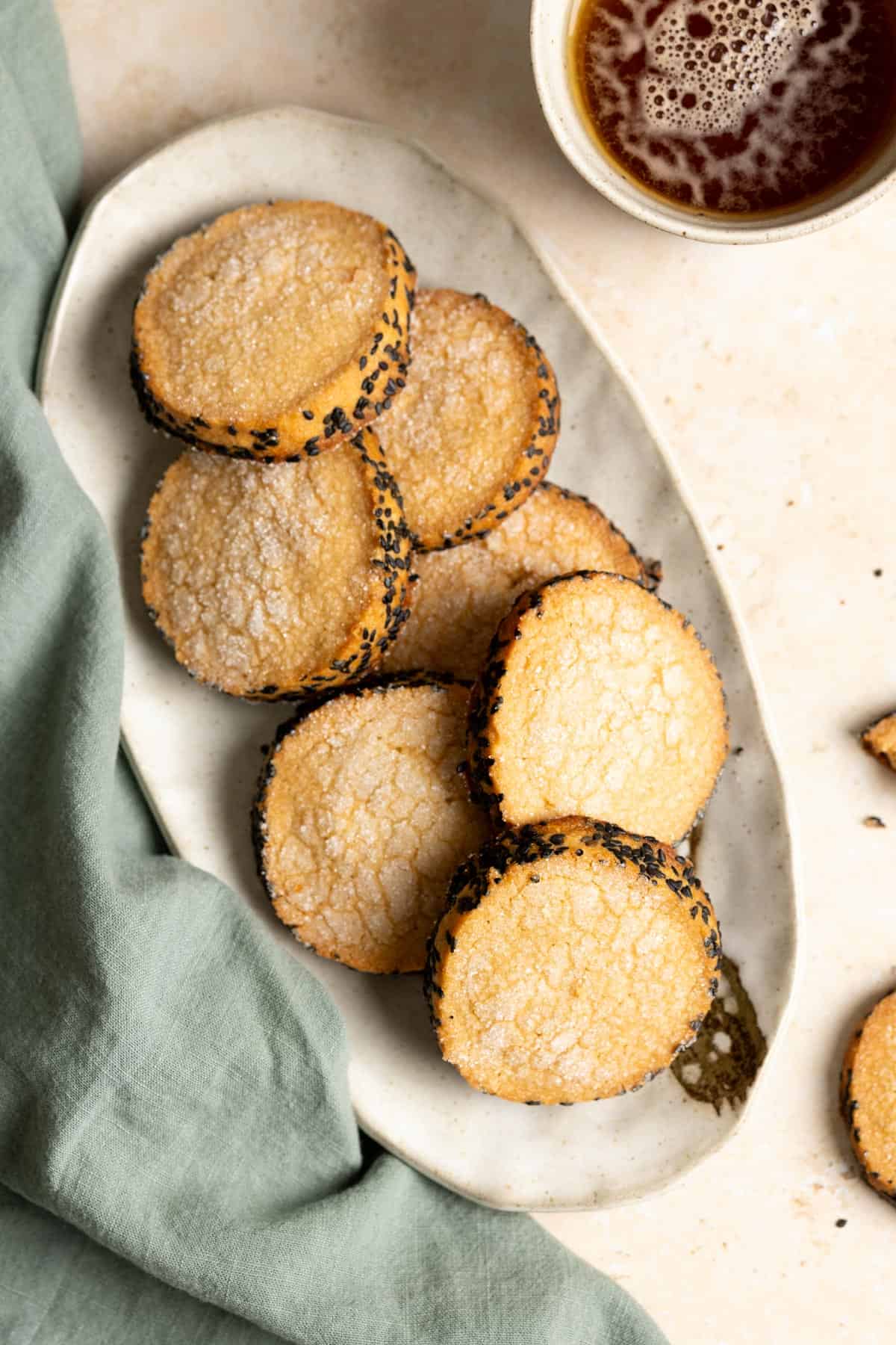Top down view of a plate of miso shortbread cookies next to a green tea towel.