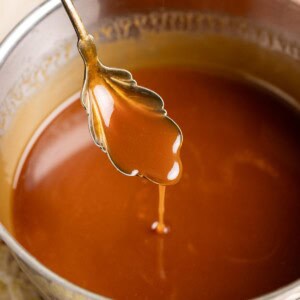 A spoonful of miso caramel drizzling into a pan.