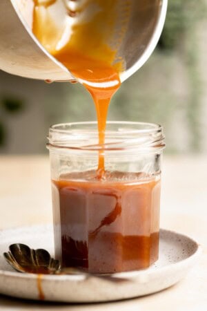 Transferring miso caramel sauce into a glass jar.