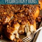 A half eaten pecan sticky roll with soft fluffy interior.