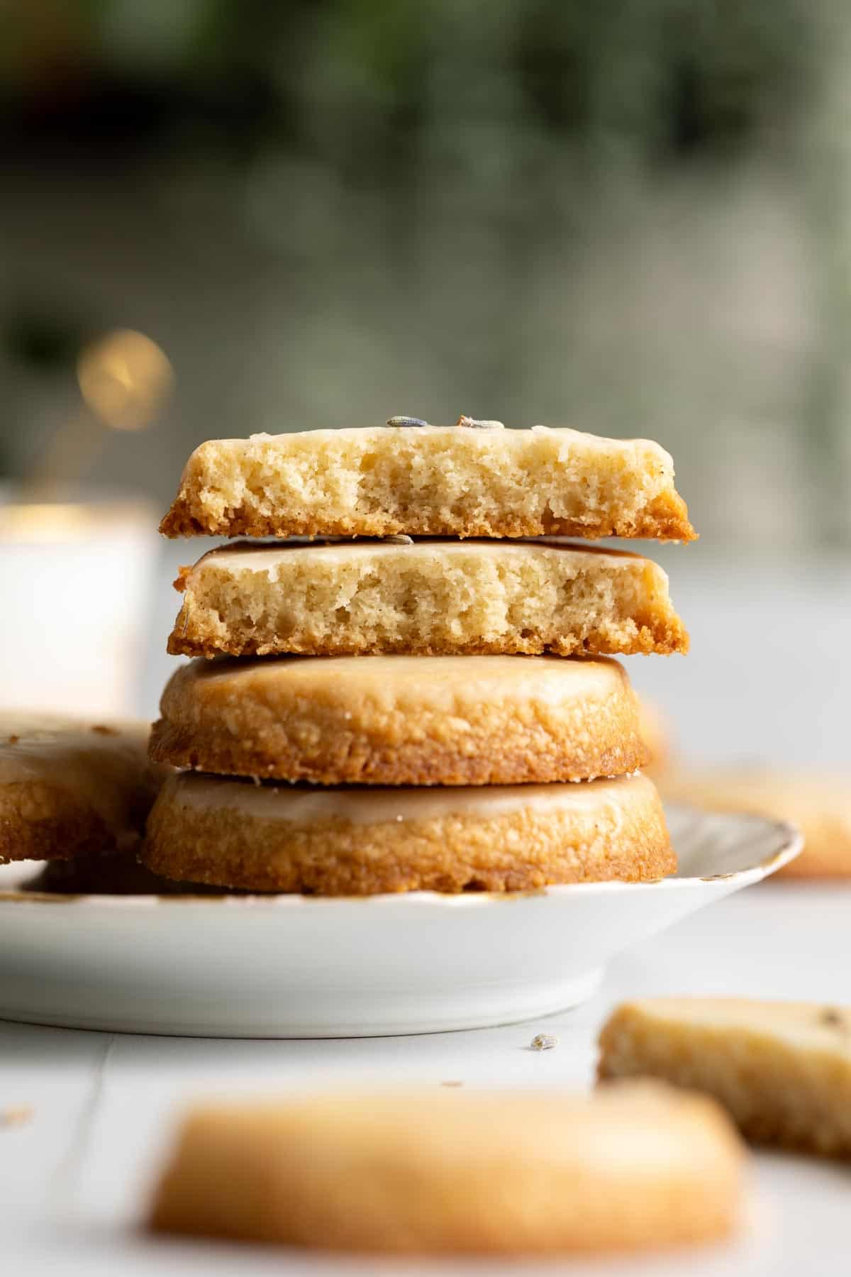A stack of lavender shortbread cookies, the top two are broken in halves.