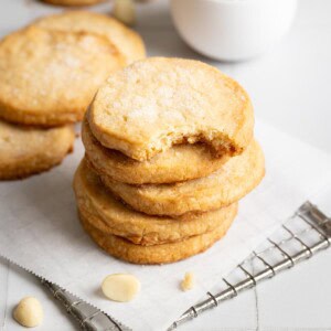 A stack of macadamia shortbread, the top one has a bite taken out of it.