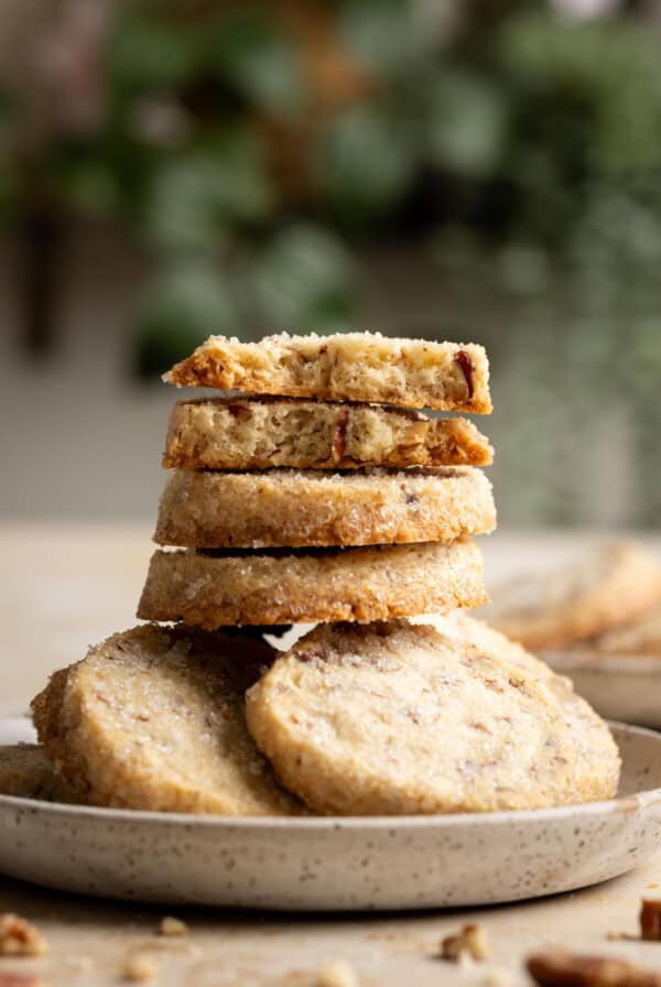 A stack of pecan shortbread cookies, the top two are halves.