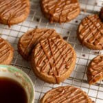 Milk tea shortbread cookies on a wire rack with cups of black tea.