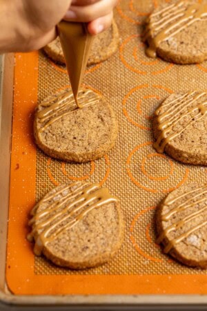 Drizzling glaze over coffee shortbread cookies.