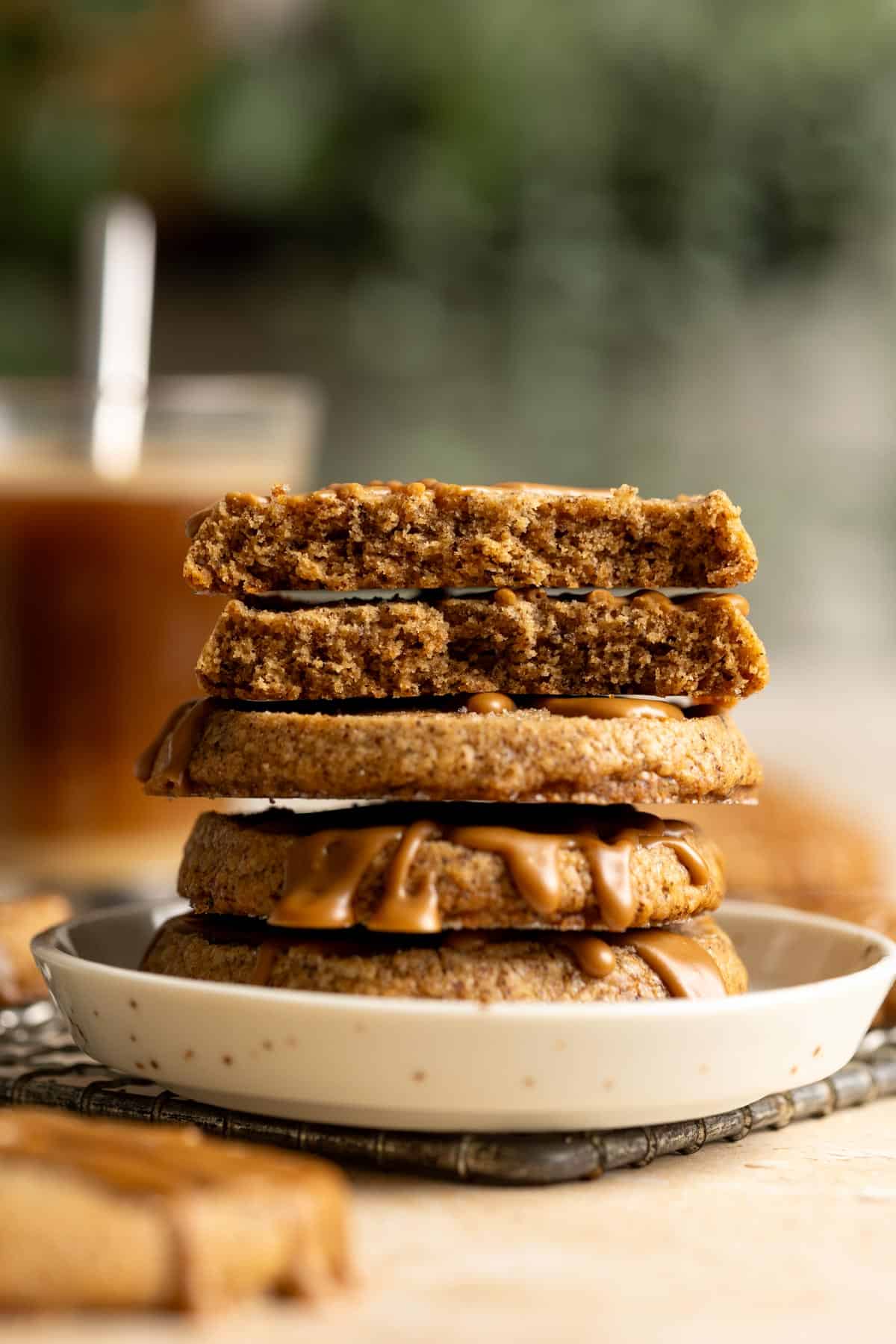 A stack of coffee shortbread on a small plate, the top two are broken in half showing interior texture.