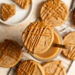 A Vietnamese coffee shortbread perching on top of a cup of coffee, more cookies are spread on the table below.