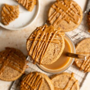 A Vietnamese coffee shortbread perching on top of a cup of coffee, more cookies are spread on the table below.