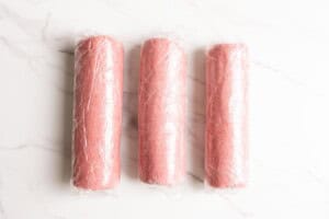 Three logs of raspberry shortbread dough.