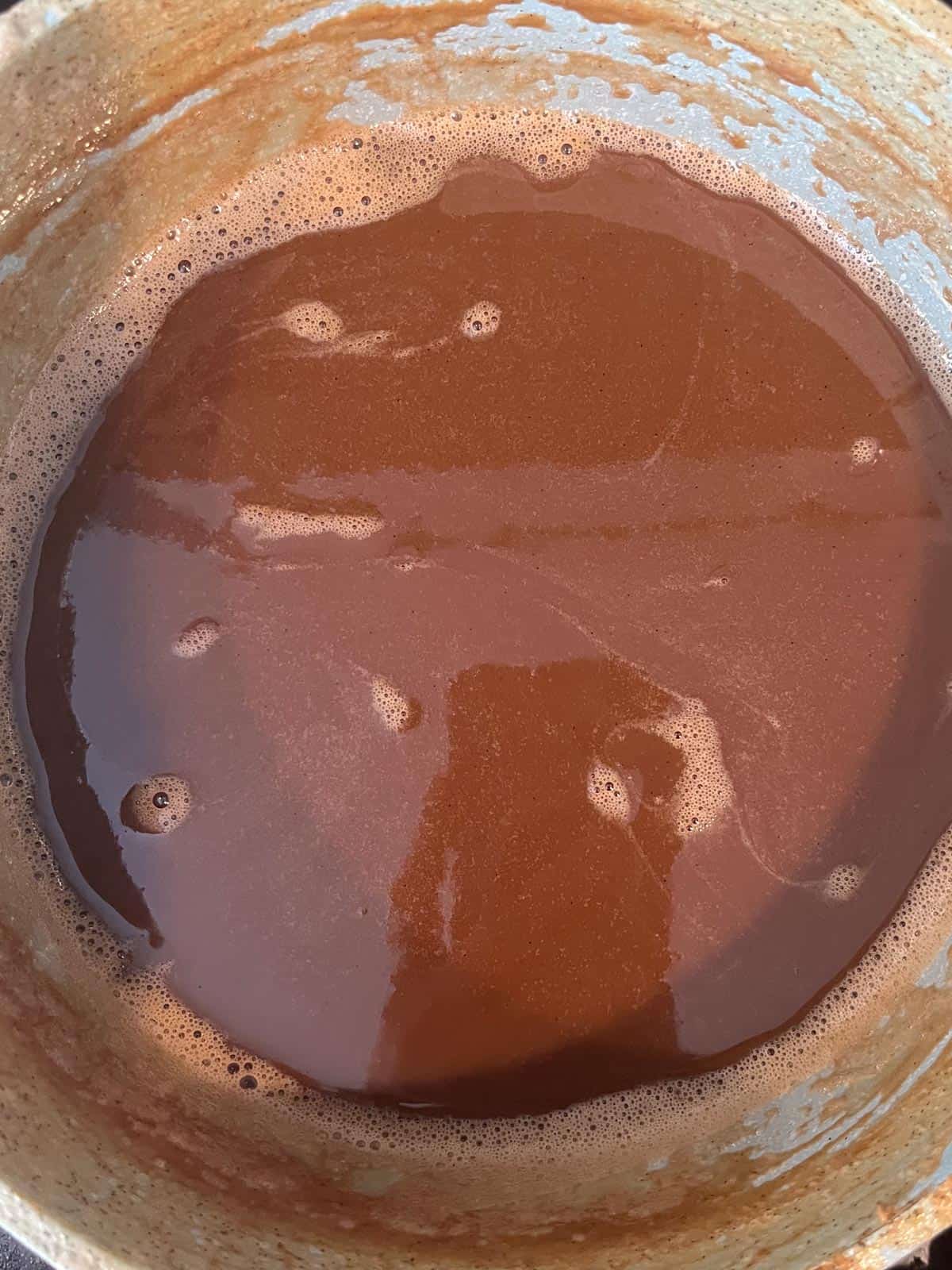 A dark brown mixture in a pot, almost dulce de leche, at 10:44 am.