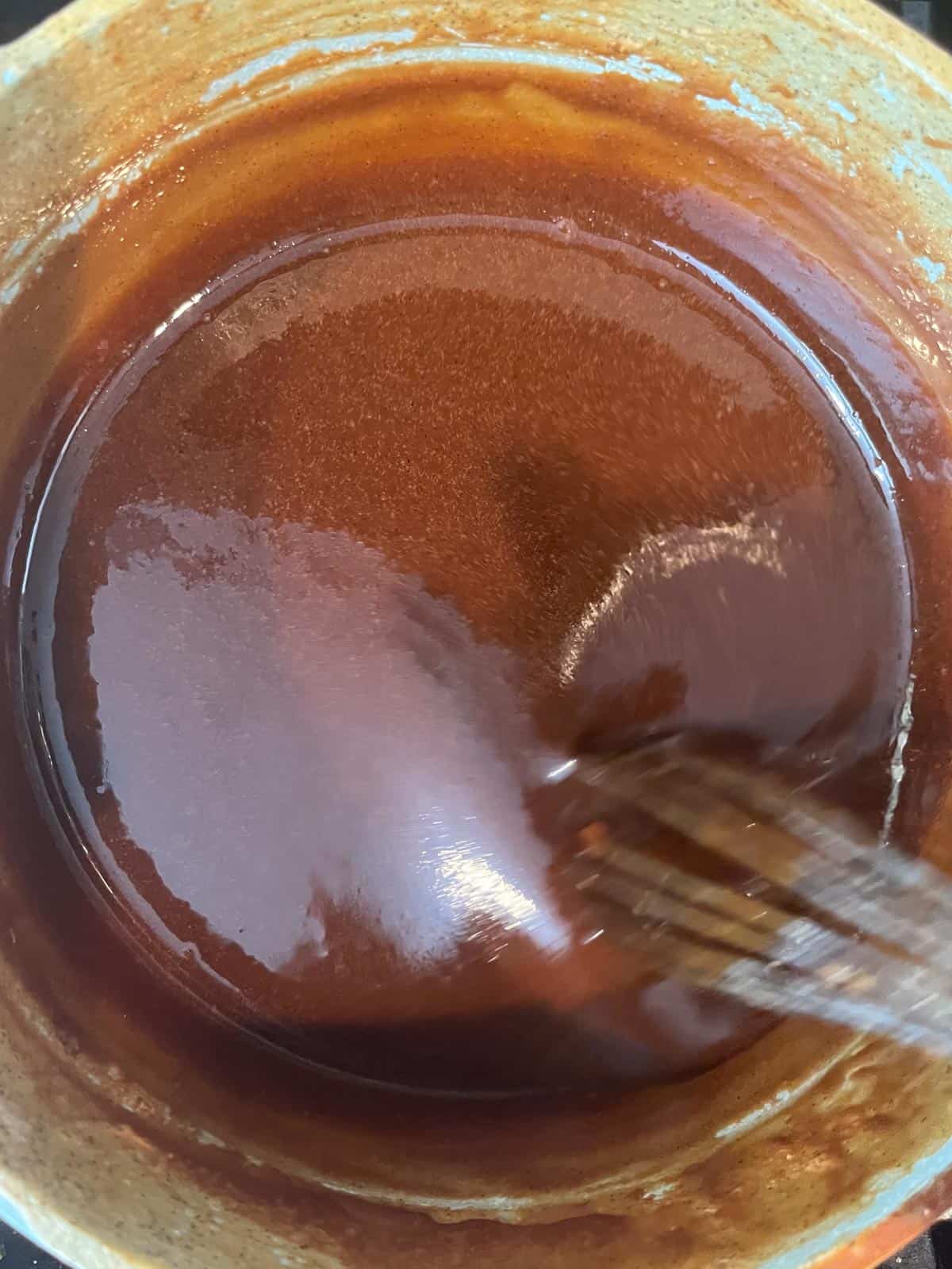 A whisk in a pot of dulce de leche.
