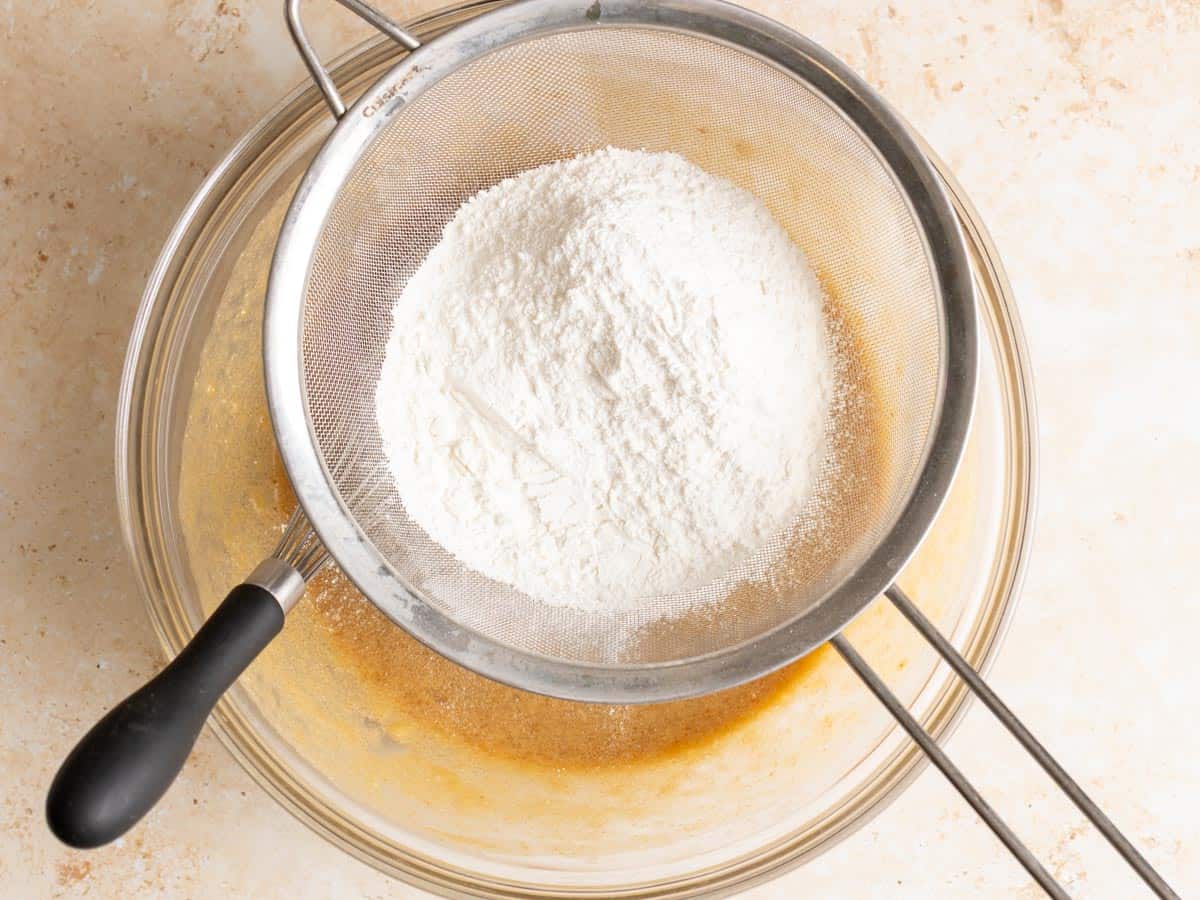 Flour is being sifted through a seive.