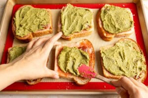 Spreading matcha almond cream on sliced bread.