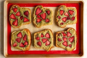 Baked matcha strawberry bostock on a baking sheet.