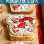 Matcha strawberry almond bostock dusted to powdered sugar on a baking sheet.