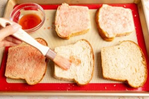Dabbing sliced bread with strawberry syrup.