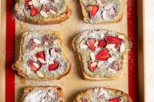 Powdered sugar and sliced almonds are added on top of bostock pastries.