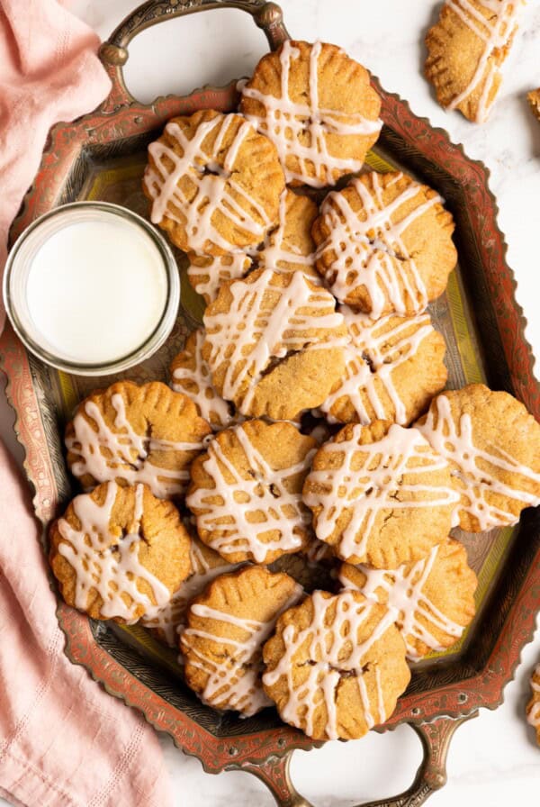 A tray of miso peanut butter cookies with jam and glass of milk.
