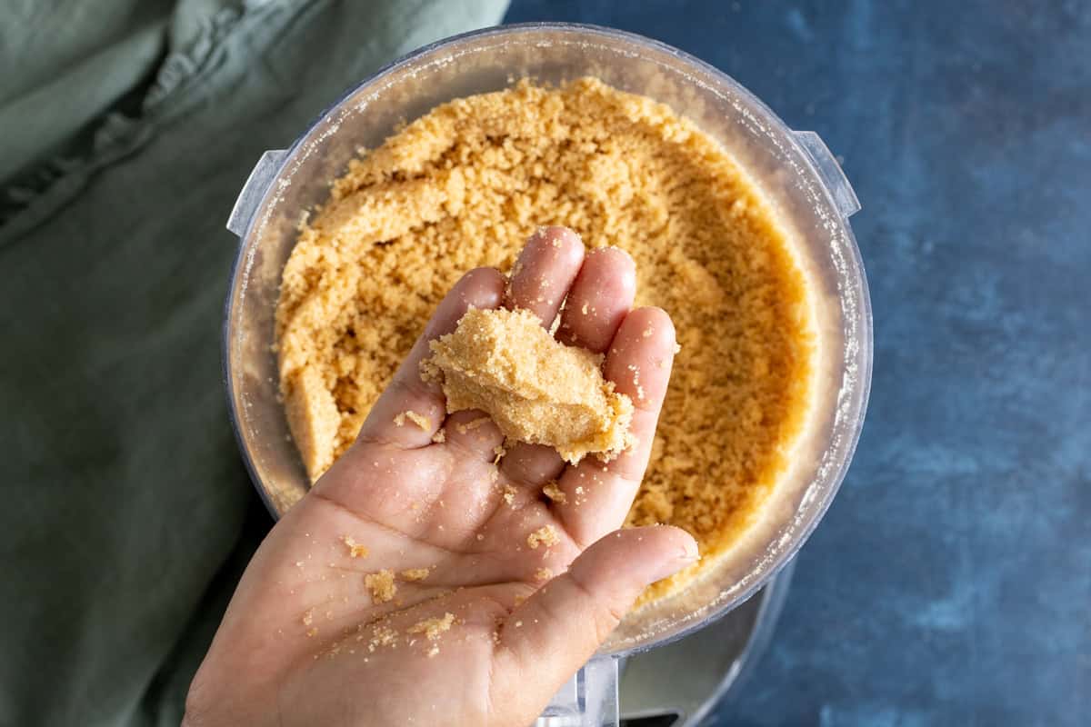 Vanilla wafer pie crust mixture pressed together on a hand.