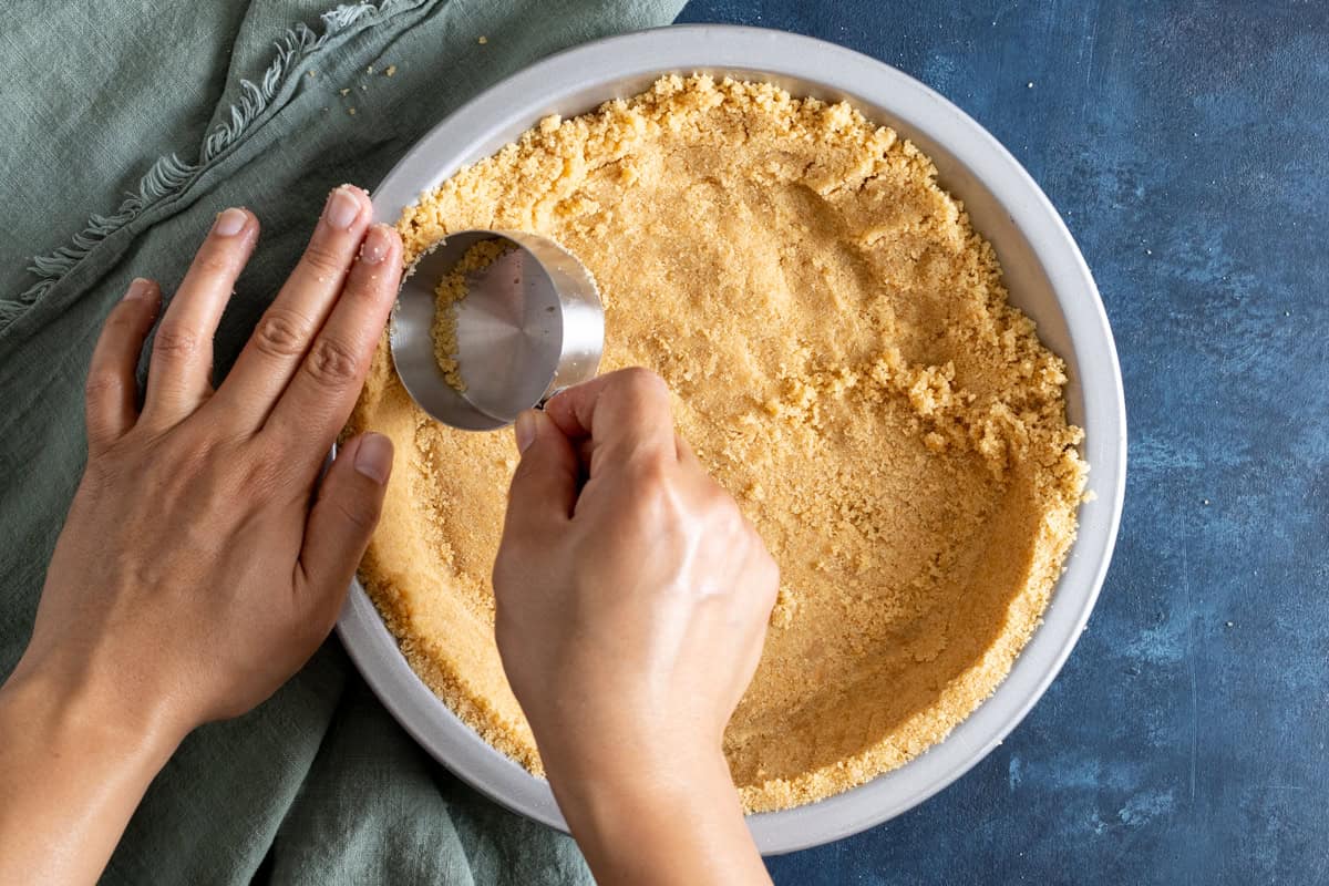 Pressing vanilla wafer crust into a pie pan.